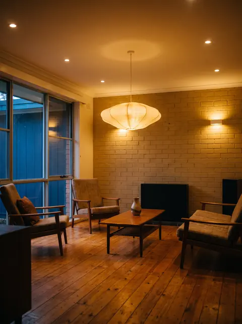 The same room glowing with new pendant, wall and down lighting